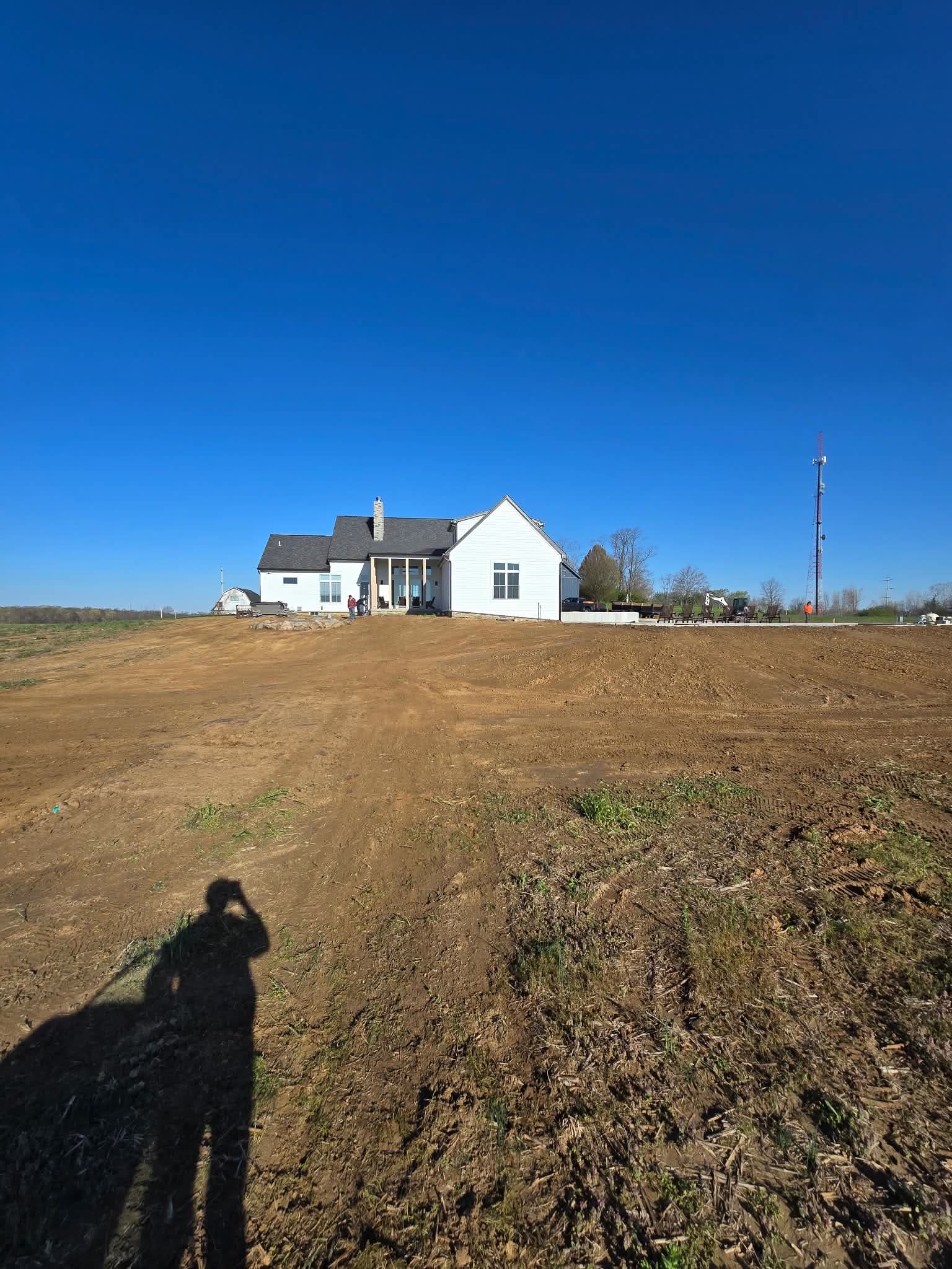 A graded and shaped field behind a new build, ready for seed
