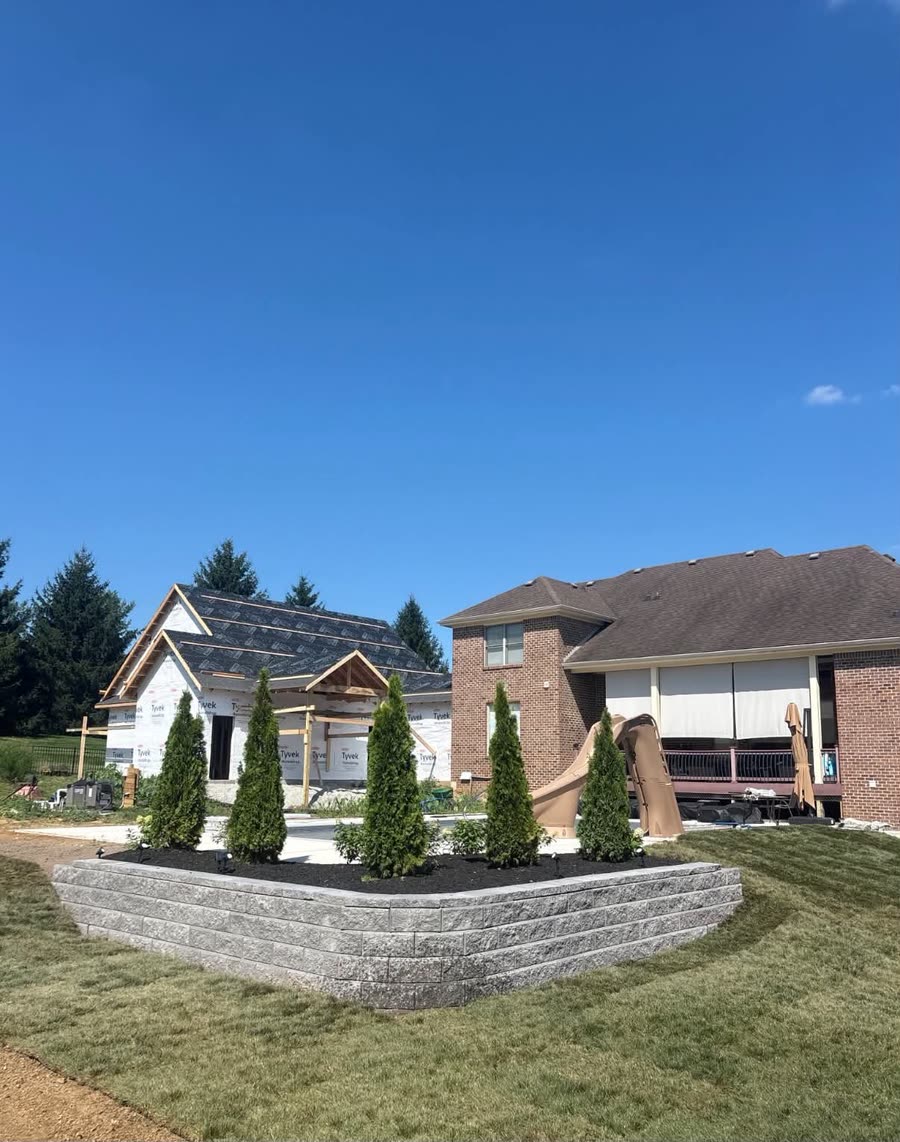 A block retaining wall planted with arborvitae